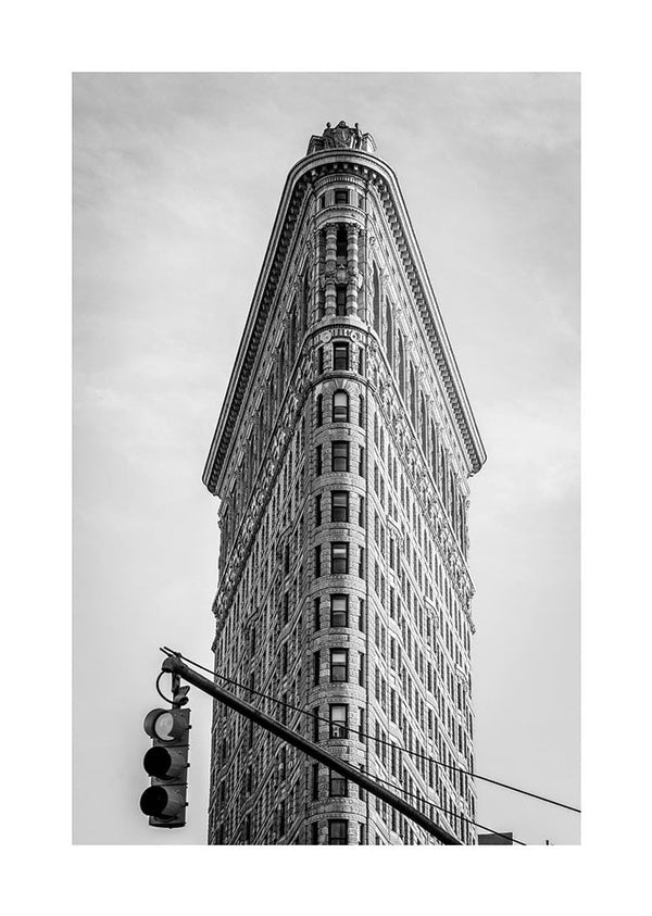 Black and white poster of the Flatiron Building in New York City with a traffic light in the foreground.