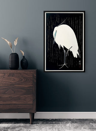 Egret standing in rain, Japanese woodblock print by Ohara Koson, framed poster on a modern room wall.