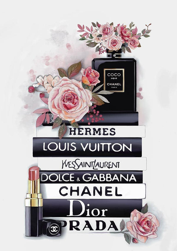 Chanel perfume, lipstick, and roses displayed on stacked books featuring top fashion brands’ names.