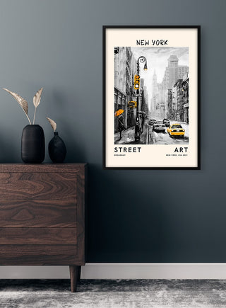 Framed "Street Art - New York" poster on a dark wall above a wooden dresser in a modern room.