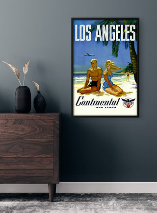 Framed Los Angeles vintage travel poster featuring a beach scene, displayed above a modern wooden dresser.