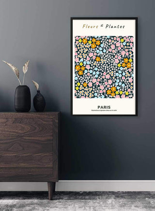 Fleur et Plantes Pink Plakat poster featuring colorful floral art, framed and hung on a dark wall above a wooden cabinet.