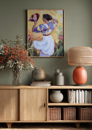 Woman with a Tulip by Elena Avanesova above a wooden sideboard on a sage green wall