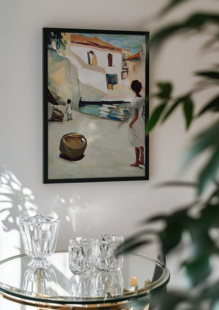 Village Street by Elena Avanesova in a black frame above a glass table with crystal glassware