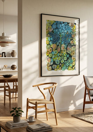 Tree of Circles by JHN.ByHjort in a black frame in a bright dining room with wooden chairs