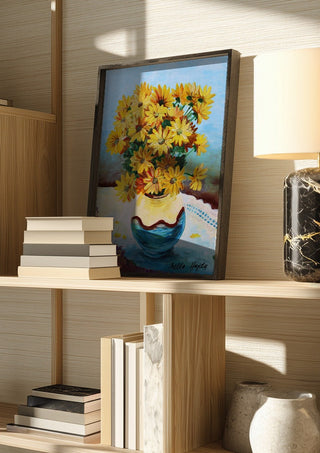 Yellow flowers by Nella Hajdu in a dark frame on a wooden shelf beside books and a lamp
