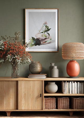 Letargo II by Rocio Montoya above a wooden sideboard on a sage green wall