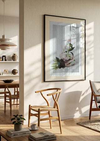 Letargo II by Rocio Montoya in a black frame in a bright dining room with wooden chairs