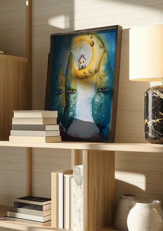 Whispering Trees by Evgenia Smirnova in a dark frame on a wooden shelf beside books and a lamp