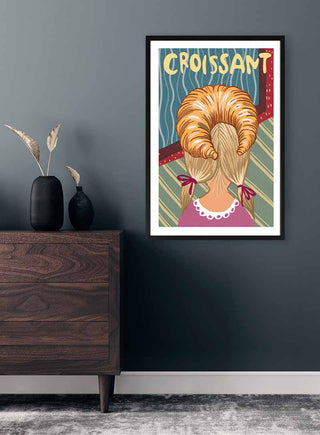 Framed På Hovedet Croissant - Nina Broen print showing a woman with croissants styled as hair, on a wall.