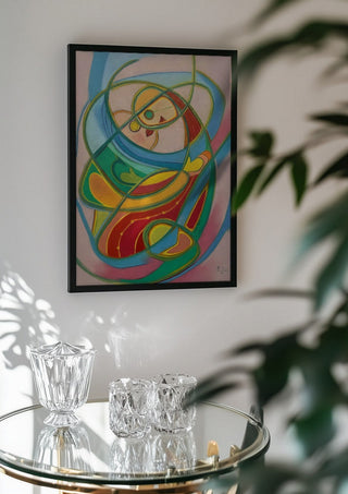 Embrace by Gerard Ceulemans in a black frame above a glass table with crystal glassware