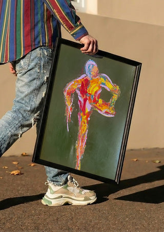 Figure in Motion by René J carried in a black frame along a sunny street