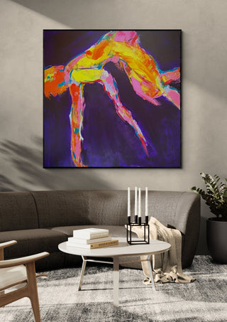 Leap by René J in a black frame above a grey sofa with a round coffee table and candlesticks