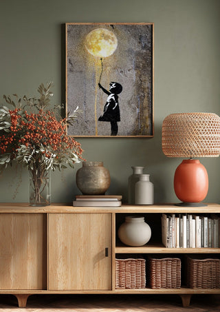Moon Balloon by Decker Studios above a wooden sideboard on a sage green wall