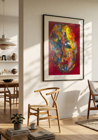 Colour Mask by René J in a black frame in a bright dining room with wooden chairs