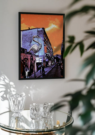 Brick Lane Pelican by Pelecan Schneider in a black frame above a glass table with crystal glassware