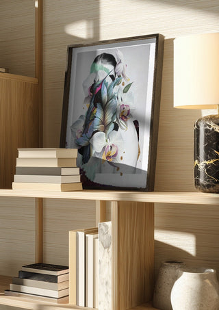 Blue Nostalgia by Rocio Montoya in a dark frame on a wooden shelf beside books and a lamp