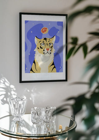 Grrrapefruit by Jakob Falkenberg in a black frame above a glass table with crystal glassware