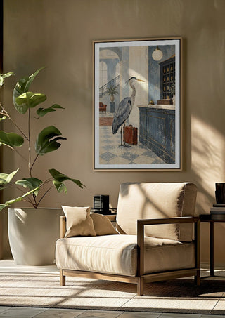 The Heron Checks In by Matthews Gallerie framed above a beige armchair beside a potted plant