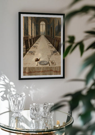 The Snail Arrives Early by Matthews Gallerie in a black frame above a glass table with crystal glassware