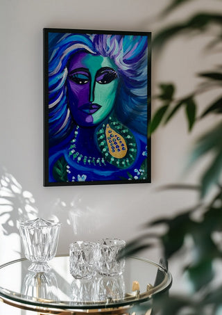 Blue Muse by Da Winters in a black frame above a glass table with crystal glassware