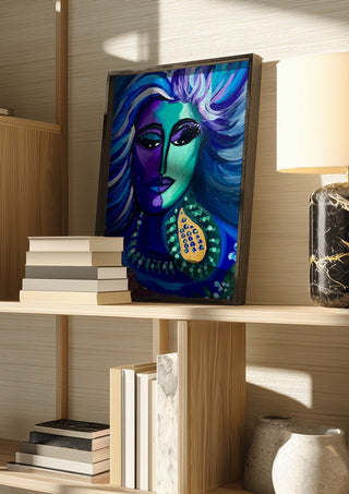 Blue Muse by Da Winters in a dark frame on a wooden shelf beside books and a lamp