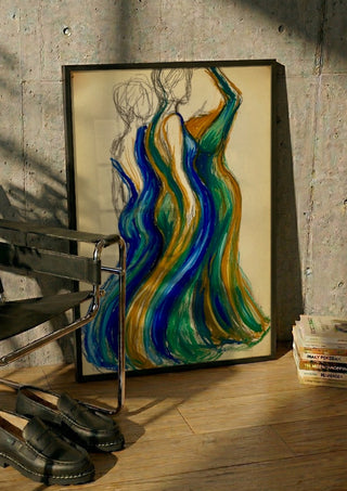 Two Gowns by Da Winters in a black frame leaning against a concrete wall by a steel chair