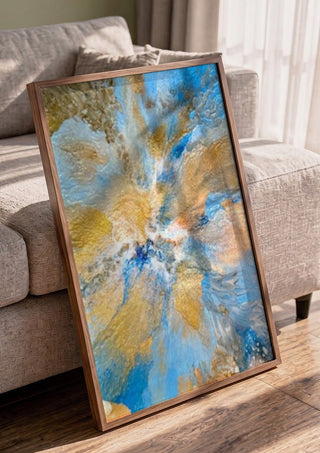 Sand and Sky by Da Winters in a walnut frame leaning against a grey sofa