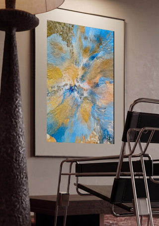 Sand and Sky by Da Winters framed in a dim room beside a tubular steel chair
