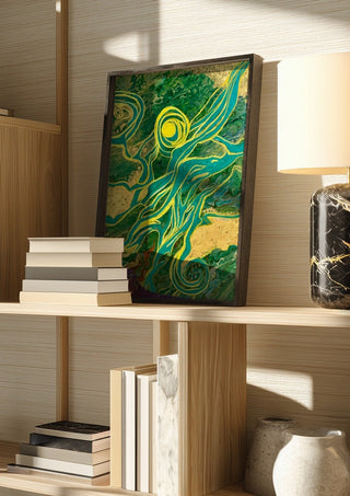 Golden Vines by Da Winters in a dark frame on a wooden shelf beside books and a lamp