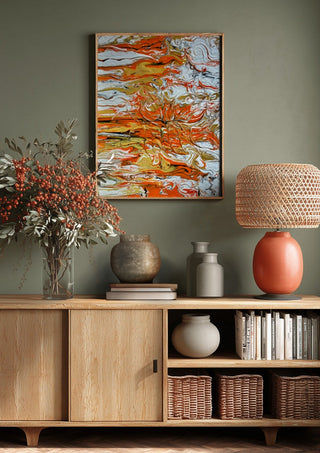 Orange Tide by Da Winters above a wooden sideboard on a sage green wall