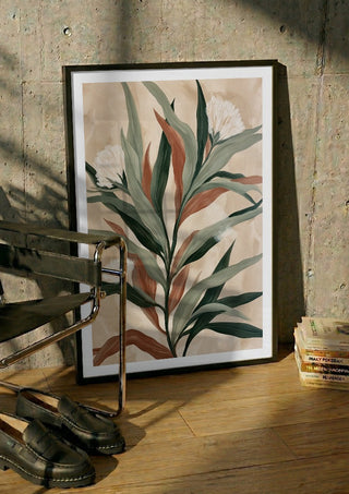 Sage and Rust by Martina Karlsson in a black frame leaning against a concrete wall by a steel chair