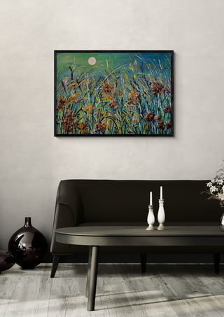 Meadow Moon by Svetla Stoyanova Bassi in a black frame above a dark sofa with candlesticks and a vase
