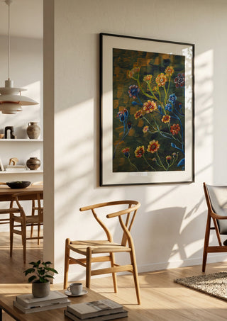 Field Flowers in Olive by Svetla Stoyanova Bassi in a black frame in a bright dining room with wooden chairs