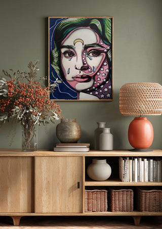 Audrey Hepburn by Okiana above a wooden sideboard on a sage green wall