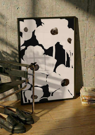 Abstract Flowers by ThingDesign in a black frame leaning against a concrete wall by a steel chair