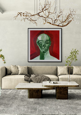 Green portrait / red field by Linor Citaku in a black frame above a cream sofa under a branch chandelier