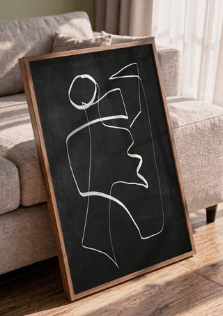 Form in Motion by ThingDesign in a walnut frame leaning against a grey sofa