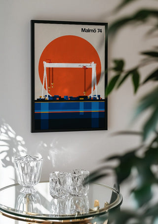 Malmö 74 by Bo Lundberg in a black frame above a glass table with crystal glassware