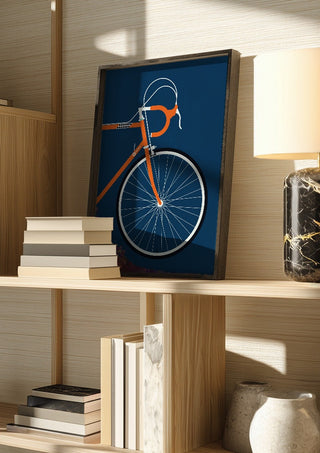 Swedish Racing Bike - Detail by Bo Lundberg in a dark frame on a wooden shelf beside books and a lamp