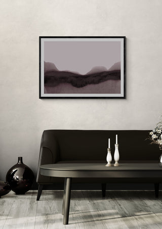 abstract moody landscape by Iris Lehnhardt in a black frame above a dark sofa with candlesticks on a round table