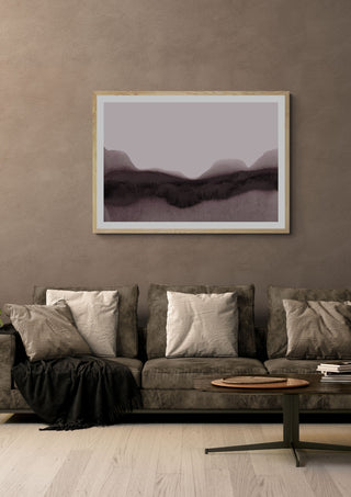 abstract moody landscape by Iris Lehnhardt in a light oak frame above a grey sofa on a warm brown wall
