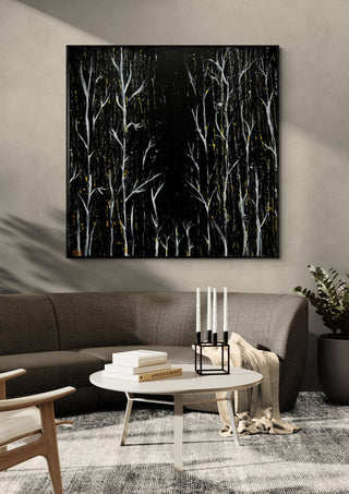 White Birches at Night by Marcel Herrmann in a black frame above a dark sofa with candlesticks on a round table