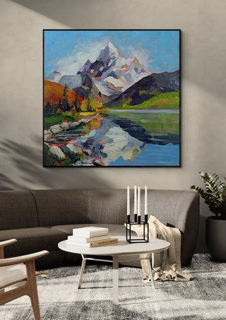 Still Waters, Endless Peaks by Evgenia Smirnova in a black frame above a dark sofa with candlesticks on a round table