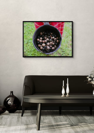 Dye with Ebony by Elefteria in a black frame above a dark sofa with candlesticks on a round table
