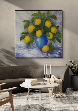 Lemons for You and Me by Tako in a black frame above a dark sofa with candlesticks on a round table