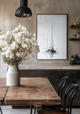 Two Masts by Justyna Kopania in a black frame above a rustic table with white flowers