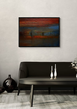 Red Horizon by Justyna Kopania in a black frame above a dark sofa with candlesticks on a round table