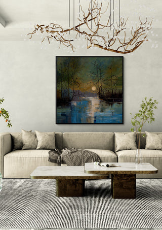 Sun over Still Water by Justyna Kopania in a black frame above a cream sofa under a branch chandelier