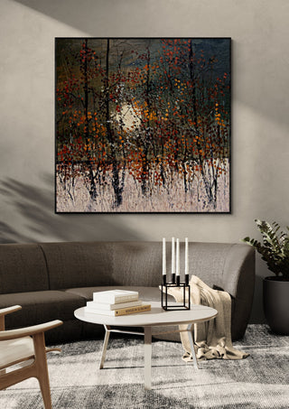 Autumn Trees in the Sun by Justyna Kopania in a black frame above a dark sofa with candlesticks on a round table
